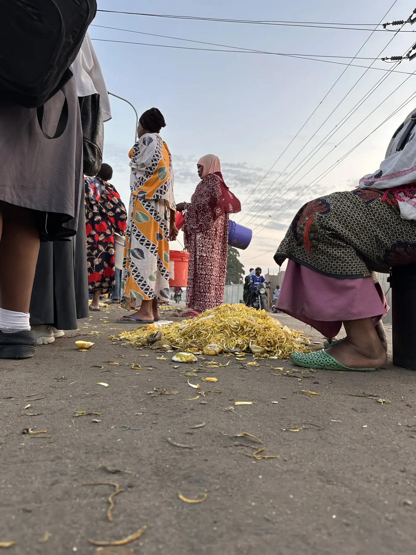 Fruit vendors beside collected citrus peel