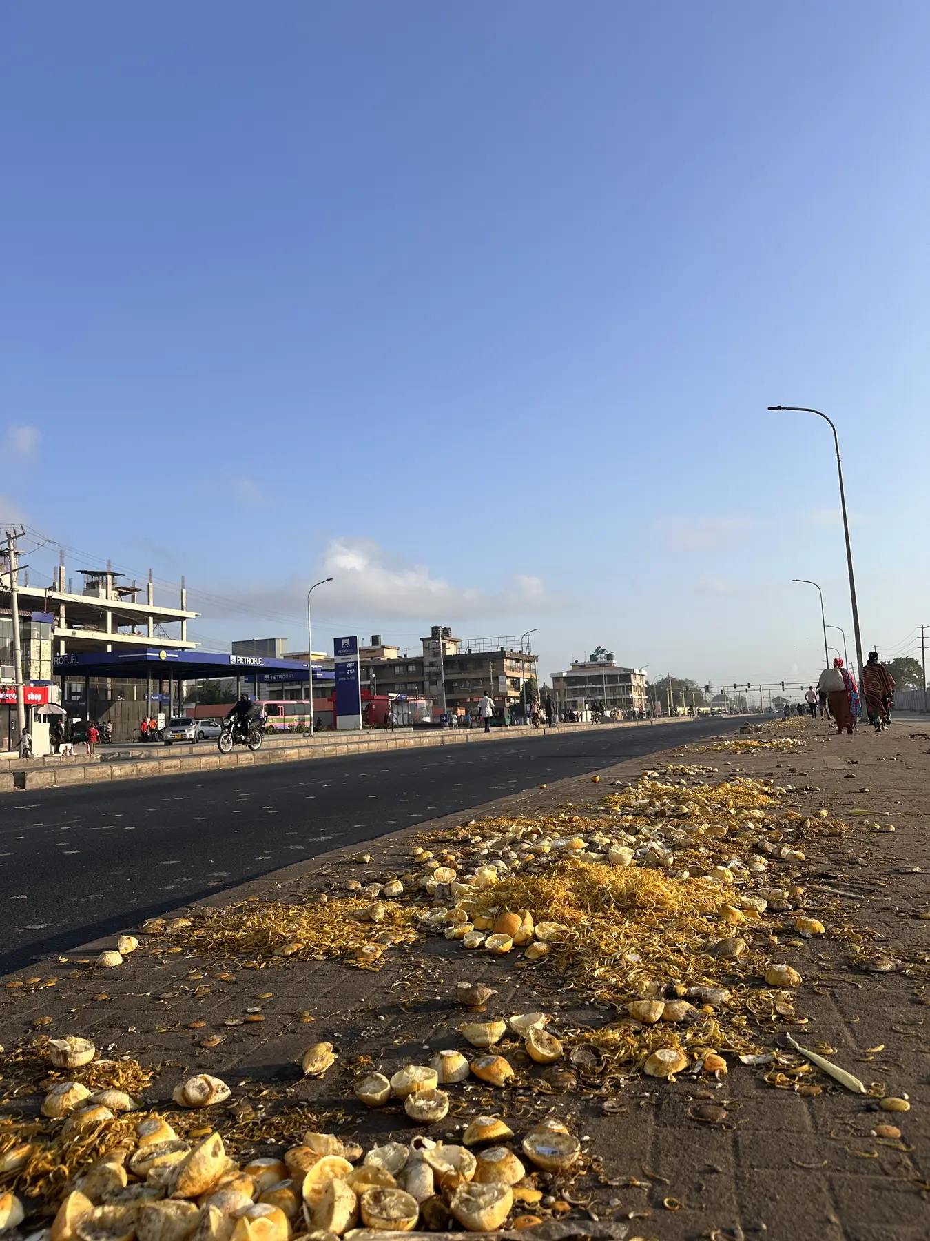 A long fruit-peel waste stream beside a local market